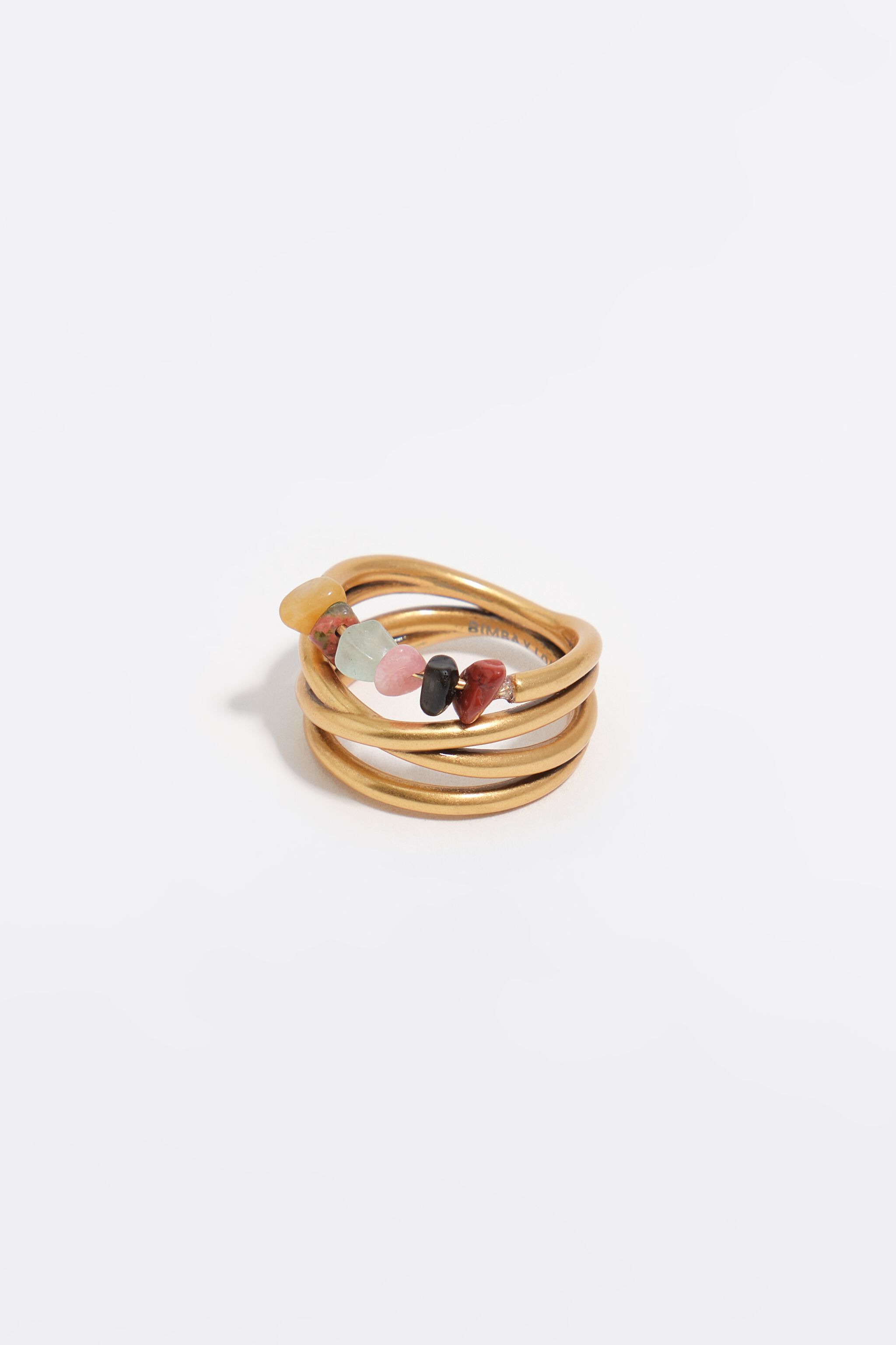 Ring aus mattgoldenen Kreuzbändern und Steinen